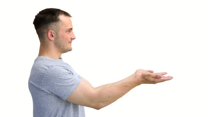 A man in a gray T-shirt, on a white background, in close-up, points to the side