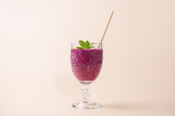 Cranberry Smoothie in vintage glass with beige straw and mint leaves, highlighting texture and color. Minimalist background. Copy Space. Concept of nutrition, freshness and healthy style