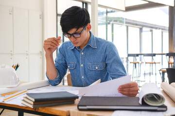 Architect working on blueprints at a modern workspace