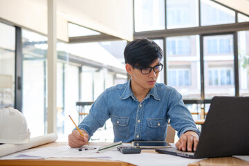 Architect working on blueprints at a modern workspace