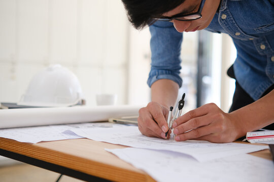 Architect designing house plans using a compass