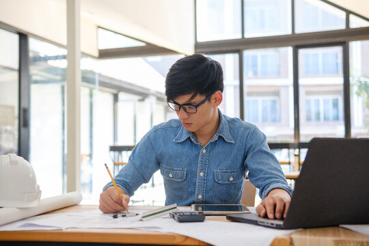 Architect working on blueprints at a modern workspace