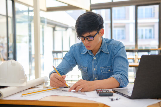 Architect working on blueprints at a modern workspace