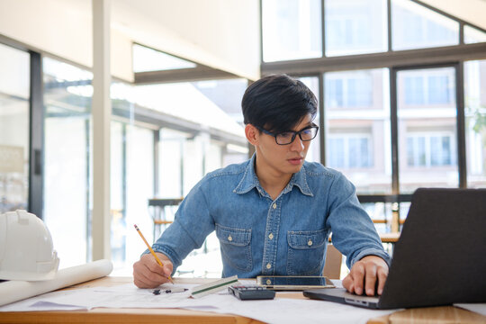 Architect working on blueprints at a modern workspace