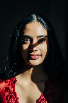 Close-up portrait of a woman in red lace, dramatic lighting