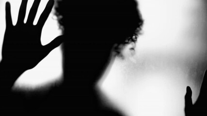 Woman Desiring Escape, Shadowy Figure Behind Blurry Glass in black and white. Person struggling with mental illness feeling despair
