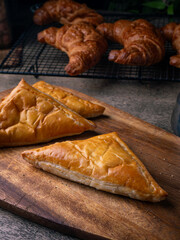 Fresh Baked puff pastry pie with filling on wooden cafe table