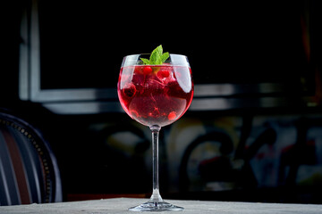 A close-up of a berry cocktail, showcasing the icy texture of the drink and the smoothness of the berries. The vibrant color of the cocktail creates a visually appealing contrast with the clear glass.