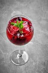 A close-up of a berry cocktail, showcasing the icy texture of the drink and the smoothness of the berries. The vibrant color of the cocktail creates a visually appealing contrast with the clear glass.