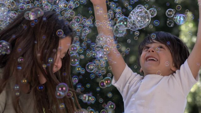 Children playing with bubbles in slow-motion at 1000 fps, surrounded by colorful bubbles, capturing a moment of joy and fun outdoors