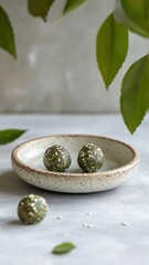 Soft and chewy matcha and white sesame energy bites beautifully arranged on a rustic wooden platter.