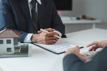 Real estate agent is listening to client offering bribe during house purchase contract signing,...