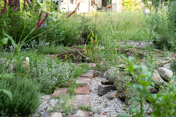 Herb Garden with Brick Path and Mini Pond / Natural garden design with herb beds featuring brick pathway, gravel borders and small metal water basin / Natural Garden Design