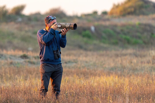 Wildlife photographer doing bird watching. - Powered by Adobe