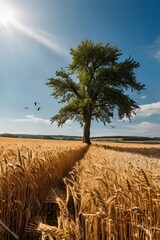 Tree stands in the middle of a field of wheat. The sky is clear and blue, and the sun is shining brightly. There are several birds flying in the sky, and one of them is perched on the tree