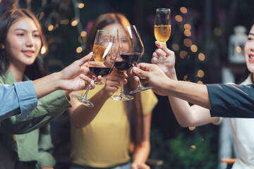 Cheers to Friendship: A group of friends raises their glasses in a toast, celebrating togetherness and good times. The warm glow of string lights adds a touch of intimacy to the scene.