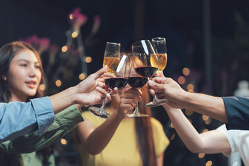 Friends Toast: A group of diverse friends raise their wine glasses in a celebratory toast, their faces illuminated by the warm glow of festive lights in the background.