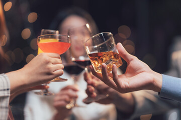 Cheers to Connection:  A close-up of four hands raise their glasses in a celebratory toast,  signifying friendship, connection, and shared moments.