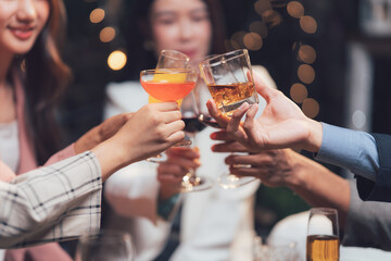 Cheers to Friendship: Close-up shot of friends making a toast, their hands holding glasses filled with different drinks, capturing the warmth and joy of a celebratory gathering. 