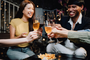 Cheers to Friendship: A group of diverse friends raise their glasses in a toast, laughing and enjoying each other's company during a lively gathering.