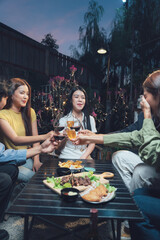 Night Out With Friends: A group of young friends gather around a table on a patio, enjoying a meal and drinks.
