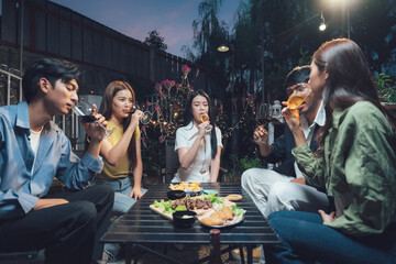 Nighttime Gathering: Friends enjoying drinks and snacks together at an outdoor party at night, creating a warm and inviting atmosphere.
