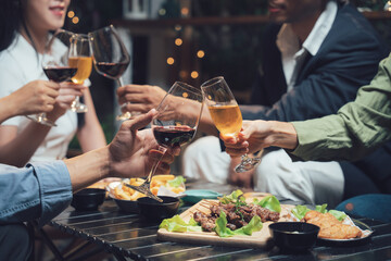 Cheers to Connection: Friends raise their glasses in a toast, capturing the warmth and joy of shared moments over delicious food and drinks. An intimate setting of friends enjoying a night out.