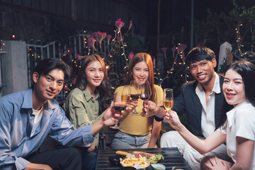 Friends Raise a Toast: A group of diverse friends joyfully raise their glasses in a celebratory toast, their smiles radiant under the soft glow of the night.
