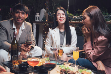 Nighttime Gathering: Friends enjoy drinks and appetizers during a lively evening gathering, sharing laughter and conversation.  