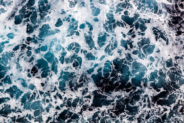 Ocean surface background. Top view of amazing foamy water. Can be used in covers, packaging, posters, textures, presentations, art, and design projects. Captivating nature background image.