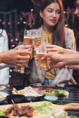 Cheers to Friendship: A group of friends raise their beer glasses in a celebratory toast, sharing laughter and good company during a lively evening gathering.