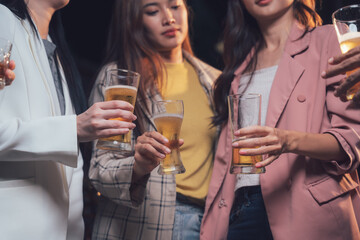 Cheers to Connection: A close-up of four women in stylish attire, their hands raised in a toast.