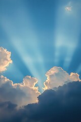 Sunbeams breaking through clouds in a blue sky.