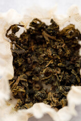 Closeup of dry tea bag on white table background.