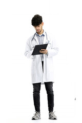 A male doctor, full-length, on a white background, writes