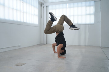 In a bright and spacious studio, a highly skilled breakdancer showcases their impressive dance talent. High quality photo