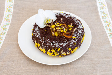 Delicious chocolate cake decorated with fresh flowers on a table