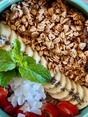 Smoothie bowl with bananas, berries, granola and other ingredients
