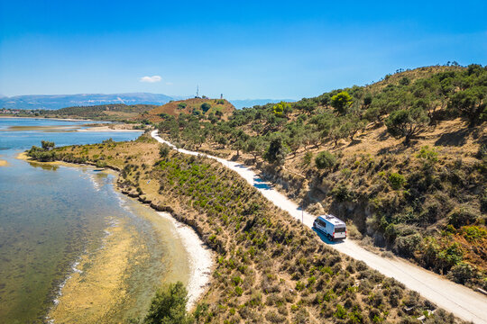 Camper van, RV or motor home is driving on gravel road from&nbsp;Zvernec beach or Dalan beach near Vlore, Albania