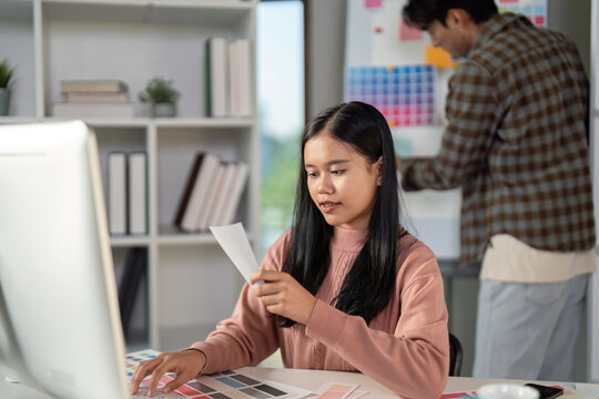 Diverse graphic design team member evaluating color palettes in a modern workspace.