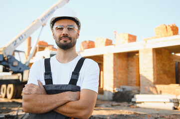 Construction worker in uniform and safety equipment have job on building. Industrial theme