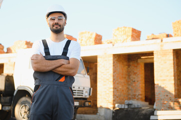 Construction worker in uniform and safety equipment have job on building. Industrial theme