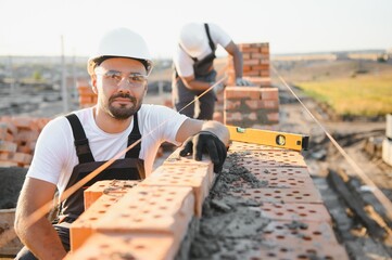 Construction worker in uniform and safety equipment have job on building. Industrial theme