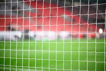 Close-up of a football soccer net on a stadium background.
