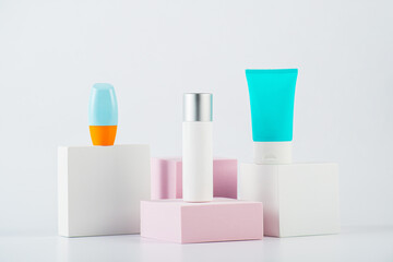 Plastic white tube for cream or lotion. Skin care or sunscreen cosmetic with stylish props on white background.