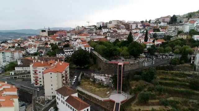 Shoted in Covilh&atilde;, Portugal. Drone moving forward, capturing the city from an upview. It shows a bridge, houses and the mountains in the back.