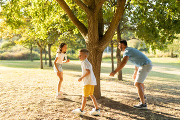 Obraz premium Father playing with kids in sunny park