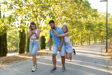 Obraz premium Family enjoying outdoor walk in sunny park