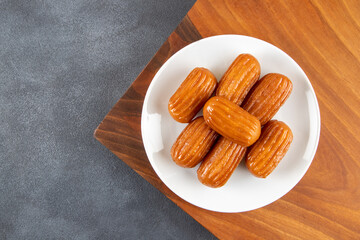 Traditional Turkish dessert tulumba on a plate. Tulumba dessert, fried in oil and soaked in syrup 