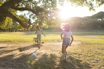 Children playing in sunlit park with trees
